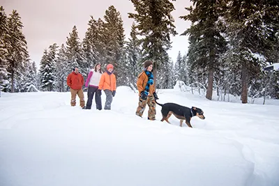 A family snowshoeing with pet