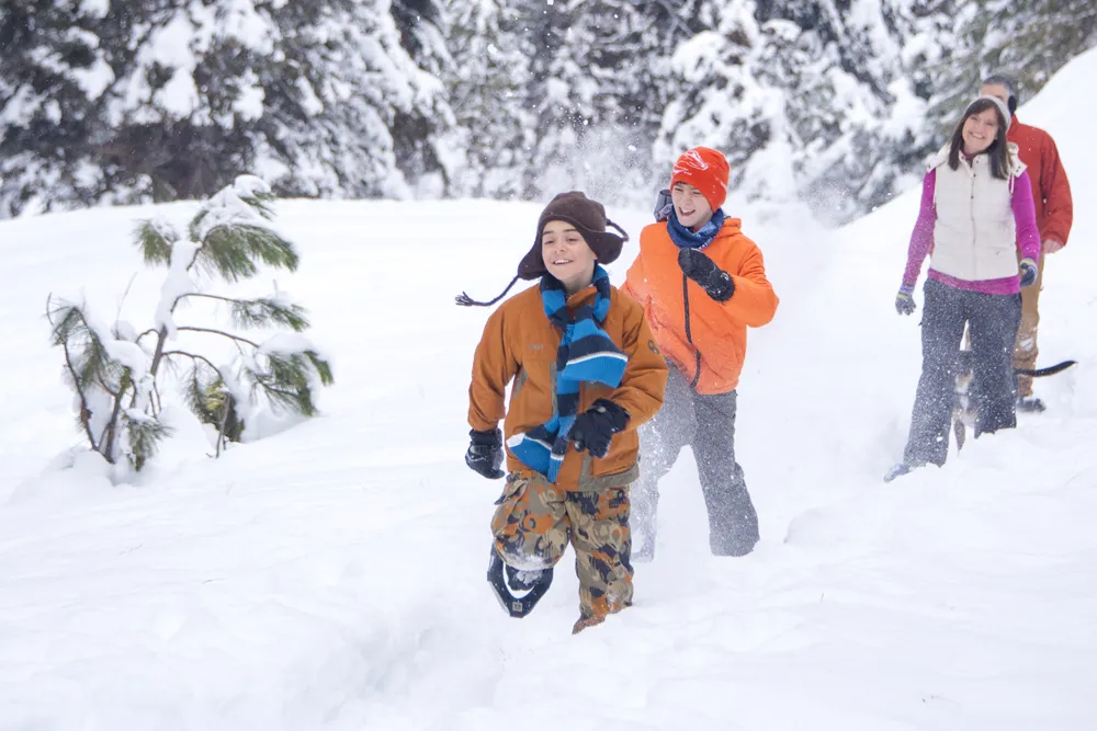 family snowshoeing in the woods