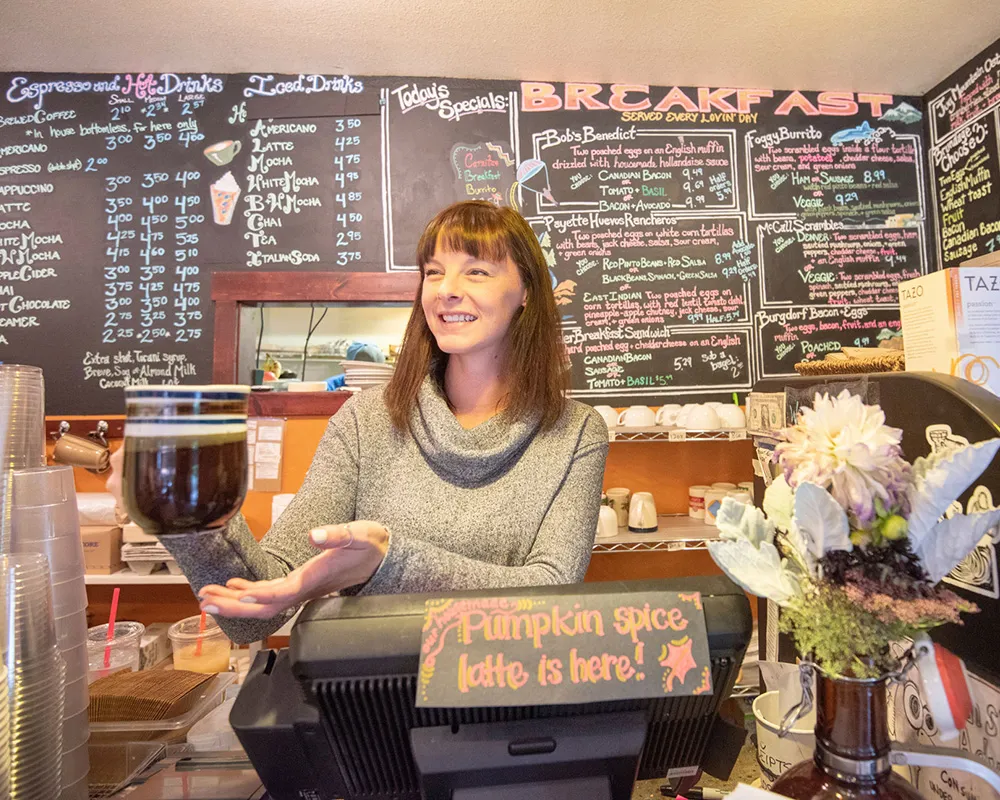 Barista at Fogglifter Cafe serving coffee