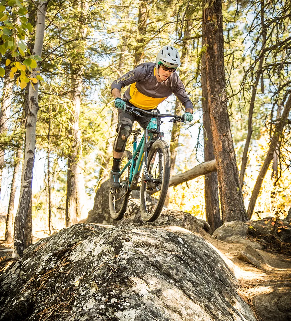 mountain biker riding downhill on rock