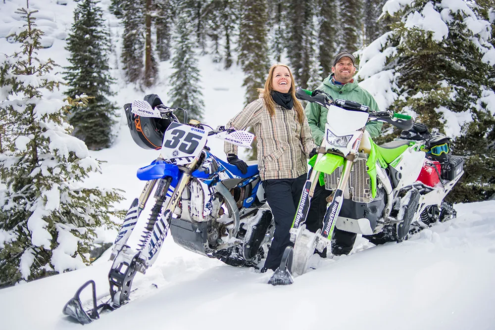 smiling couple snowbiking