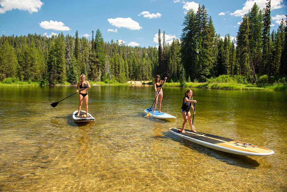 women and child paddle boarding on lazy river